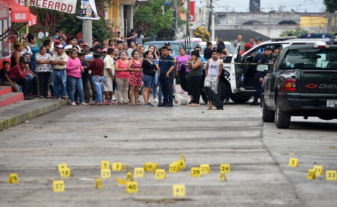 People stand near bullet casings on the ground at a crime scene after a shootout - Photo: Yahir Ceballos/REUTERS
