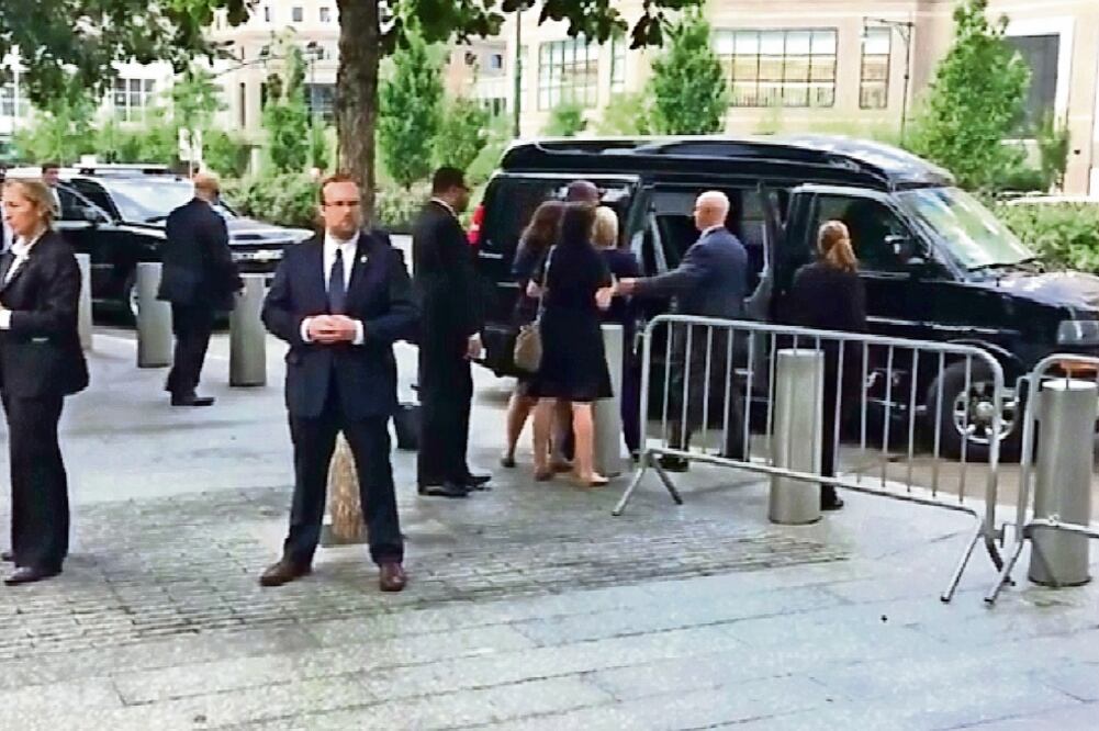 Hillary Clinton (centro, de espaldas) es sostenida por sus asistentes al retirarse del evento por los 15 años de los atentados del 11-S, en Nueva York (TOMADA DE VIDEO)