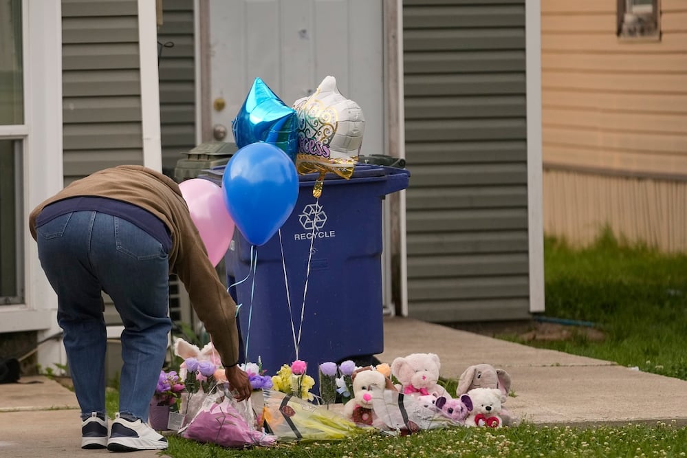 Una persona coloca un regalo en un memorial improvisado para los niños asesinados el domingo en Shreveport, Louisiana. FOTO: GERALD HERBERT. AP