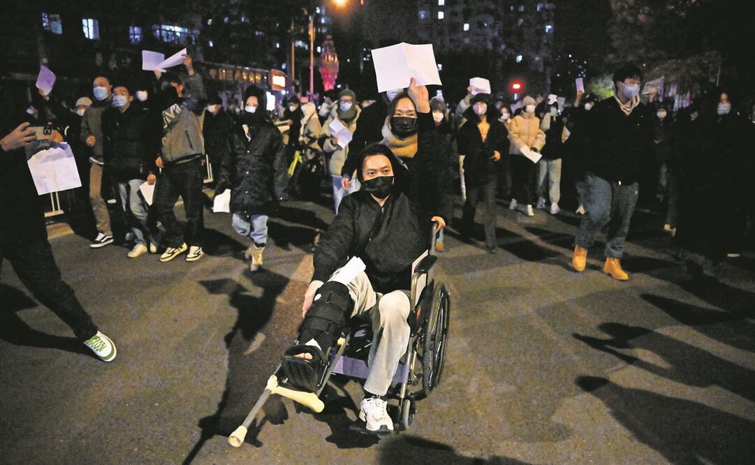 Asistentes a una manifestación en Beijing, ayer, por las víctimas de un incendio, y en protesta contra las duras restricciones por el Covid-19. Foto: Noel Celis / AFP