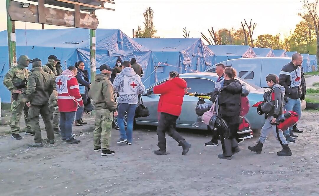 Efectivos rusos y voluntarios de la Cruz Roja escoltan a civiles evacuados del complejo acerero de Azovstal, en Mariupol. Más de 170 personas han logrado salir de la zona, y han sido trasladados a Zaporizhia.