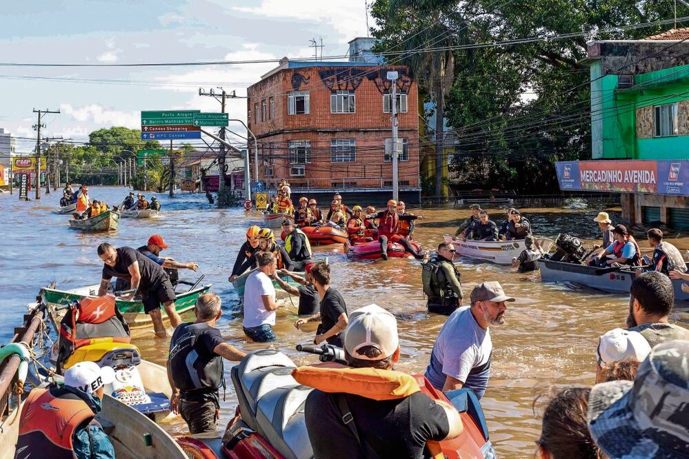 Bomberos y voluntarios durante la operación de rescate del caballo Caramelo en la ciudad de Canoas. Se calcula que hay 327 personas que fueron desalojadas de sus viviendas tras las intensas lluvias. Foto: de Guilherme Pereira. AFP