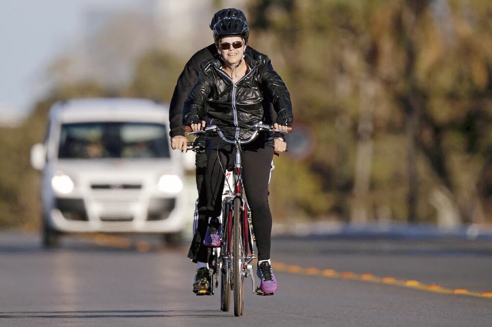 La presidenta brasileña, Dilma Rousseff, al dar ayer un paseo en bicicleta ce rca del Palacio de la Alvorada, en Brasilia (UESLEI MARCELINO. REUTERS)