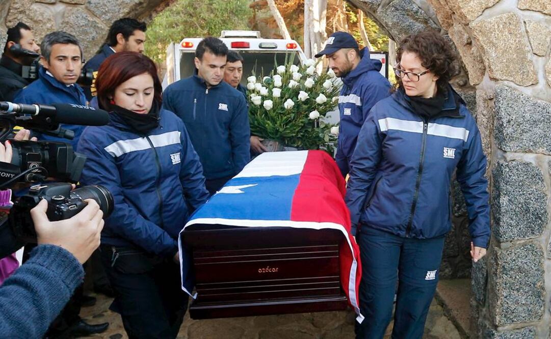 El féretro del poeta, cubierto con una bandera chilena y un ramo de rosas blancas, fue enterrado en la parte baja del jardín de la casa. FOTO: Rodrigo Garrido/Reuters.