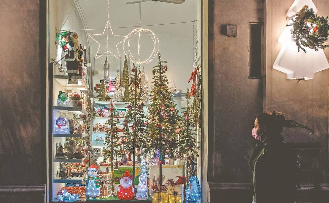 Una mujer pasa por una tienda de regalos navideños, en Roma, Italia. Ayer entró en vigor un decreto con el que, entre otras acciones, se introduce una cuarentena obligatoria para los italianos y los turistas que lleguen al país. Foto: Tiziana Fabi. AFP