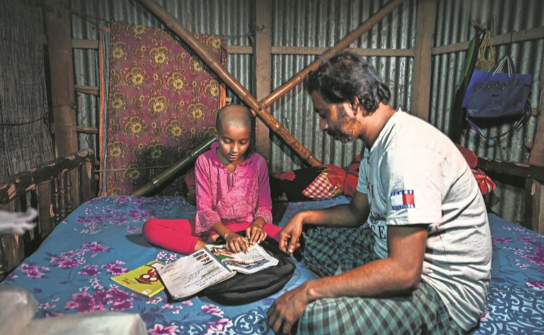 Aupon Mir, quien emigró a Qatar para trabajar en la construcción, ayuda a su hija.