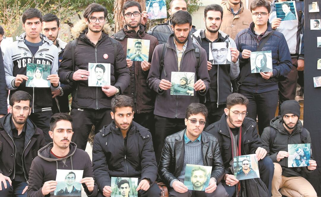 Estudiantes iraníes, con fotografías de las víctimas del derribo por error de un avión ucraniano con 176 personas a bordo en Teherán. Foto: ABEDIN TAHERKENAREH. EFE