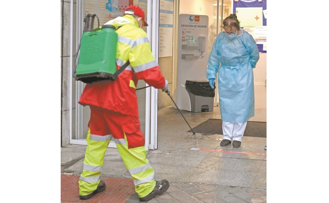 Empleados municipales desinfectan la entrada de un centro de salud en Madrid. Foto: OSCAR DEL POZO. AFP
