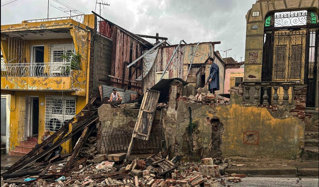 Hombres rescatan pertenencias de entre los escombros de su casa tras el derrumbe provocado por el paso del huracán Melissa por Santiago de Cuba, Cuba, el 29 de octubre de 2025. Foto: AFP