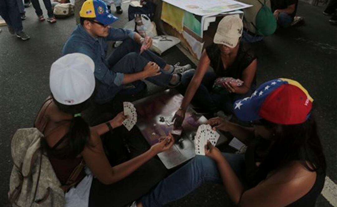Algunos juegan cartas, cantan, tocan la guitarra o leen, sentados en sillas de playa o en el asfalto y hasta acostados en colchonetas (Foto: AP)