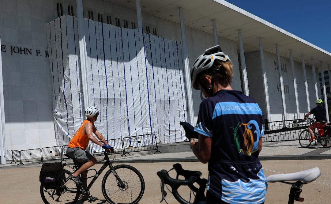 Personas en bicicleta se detienen a observar la lona que cubre el letrero del Centro John F. Kennedy para las Artes Escénicas. Foto: AP.