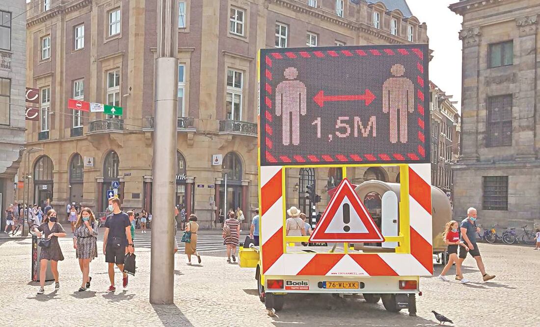 En Ámsterdam, una camioneta roja transmite el mensaje: “Stop-corona, conserva la distancia de 1.5 metros”. Foto: INDER BUGARIN. EL UNIVERSAL