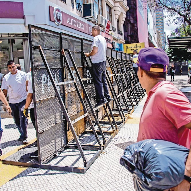 Elementos de la Policía Federal de Argentina instalan cercas en la avenida 9 de Julio, en el centro de Buenos Aires, como parte del operativo de seguridad con motivo de la cumbre del G20 que inicia mañana. Foto: MARTIN BERNETTI. AFP
