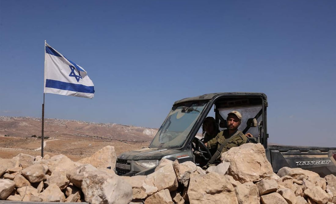 Un colono israelí con uniforme militar conduce un vehículo por un campo de olivos tras un presunto ataque de colonos contra una aldea al sur de Yatta, en la Cisjordania ocupada, el 8 de octubre de 2025. La violencia en Cisjordania se ha disparado desde que el ataque de Hamás contra Israel desencadenó la guerra de Gaza en octubre de 2023. Desde entonces, tropas y colonos israelíes han matado al menos a 983 palestinos en Cisjordania, incluidos muchos militantes, según cifras del Ministerio de Salud. Imagen ilustrativa. Foto: AFP