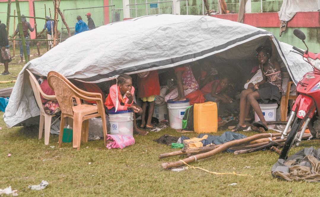 Haitianas, después de pasar la noche afuera luego del terremoto, enfrentando el severo clima causado por la tormenta tropical Grace, cerca de Les Cayes. Foto: REGINALD LOUISSAINT JR. AFP