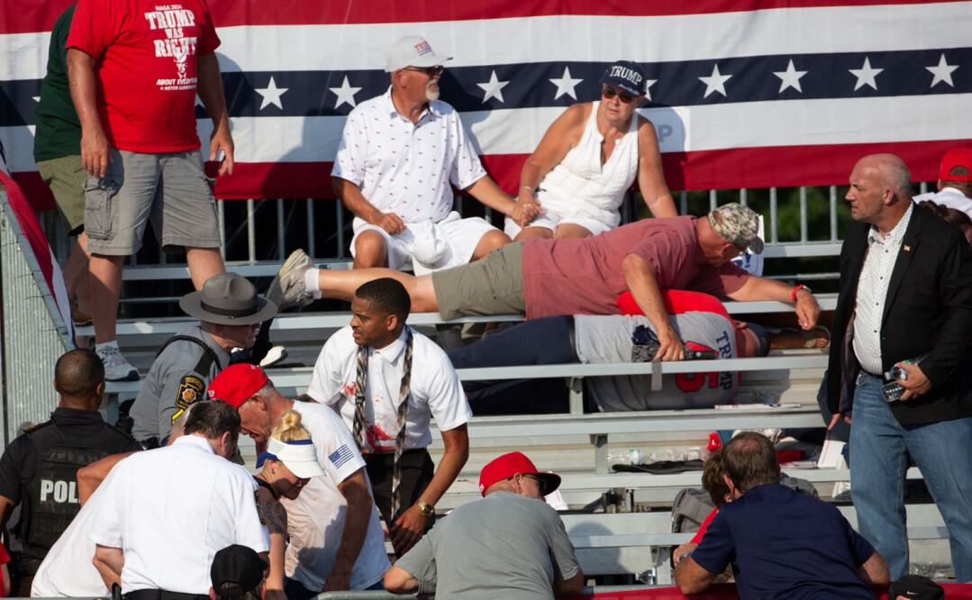 Simpatizantes resguardándose de los impactos de bala. Se encuentra el doctor que atendió durante el atentado contra Donald Trump. Foto: Rebecca DROKE / AFP