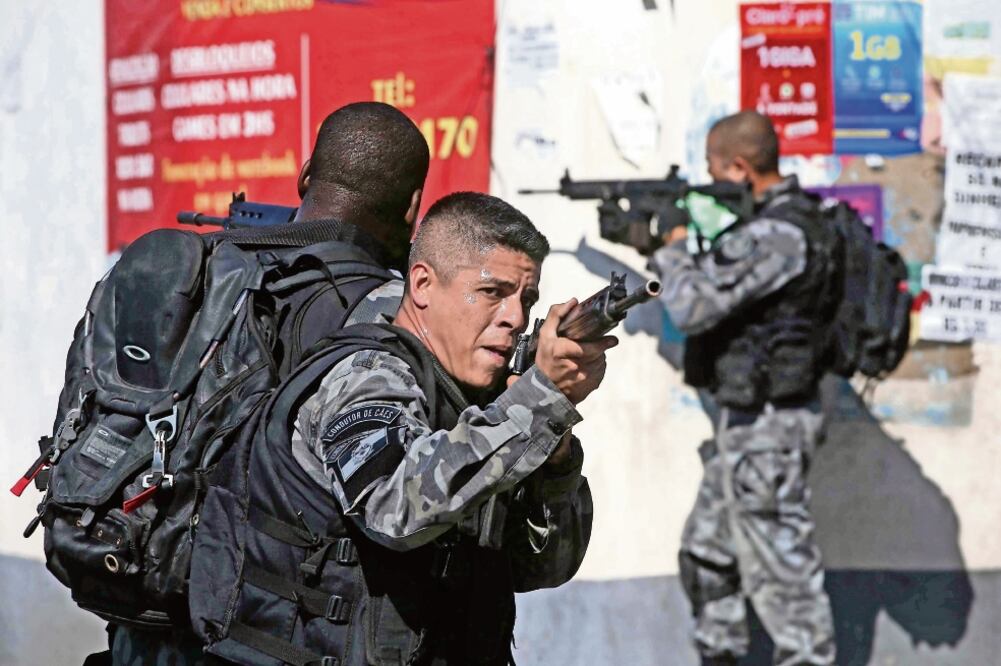 Policías militares patrullan durante un operativo en el Complexo do Alemão, donde en los últimos días se han enfrentado a narcos. (MARCELO SAYAO. EFE)