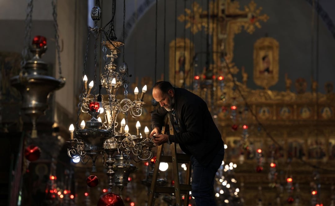 En Belén, Palestina, un palestino arregló las luces de la Iglesia de la Natividad, un lugar sagrado para los cristianos, ya que se cree que es el lugar de nacimiento de Jesucristo. (24/12/24) Foto: EFE