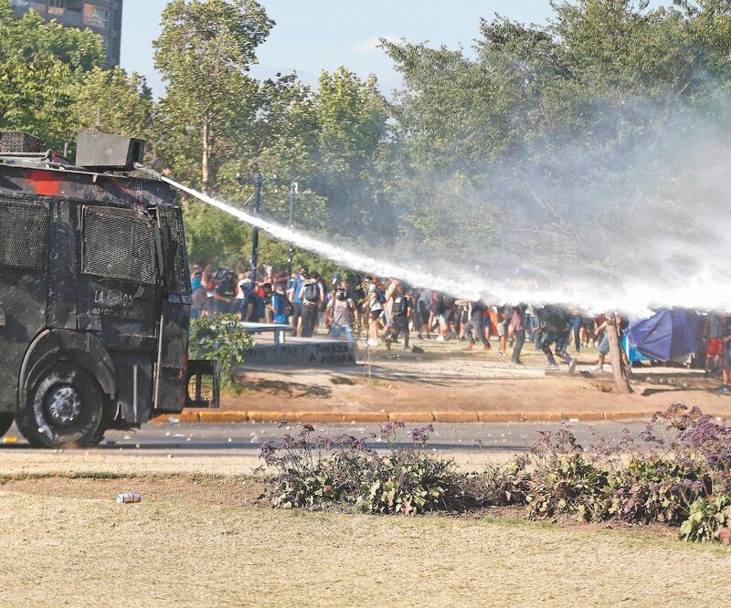 En una nueva jornada de protestas, las Fuerzas Especiales de Carabineros y manifestantes se enfrentaron en la Plaza de la Dignidad, en Santiago. ALBERTO VALDÉS. EFE