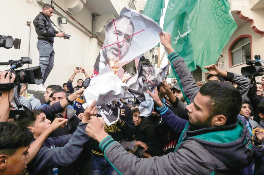 Palestinos quemaron ayer en Gaza fotos del ministro de Defensa israelí, Avigdo r Lieberman, quien anunció su dimisión. (MAHMUD HAMS. AFP)