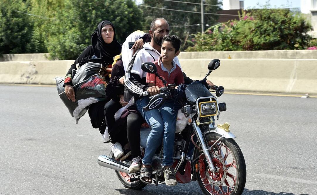 Los libaneses, que huyen del sur del Líbano, viajan en bicicleta por la autopista Damour hacia Beirut. Foto: EFE