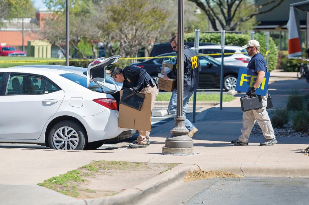 Agentes del FBI recolectan evidencia en una oficina de FedEx tras una explosión cercana, en Sunset Valley, Texas. (THAO NGUYEN BELYEU. EFE)
