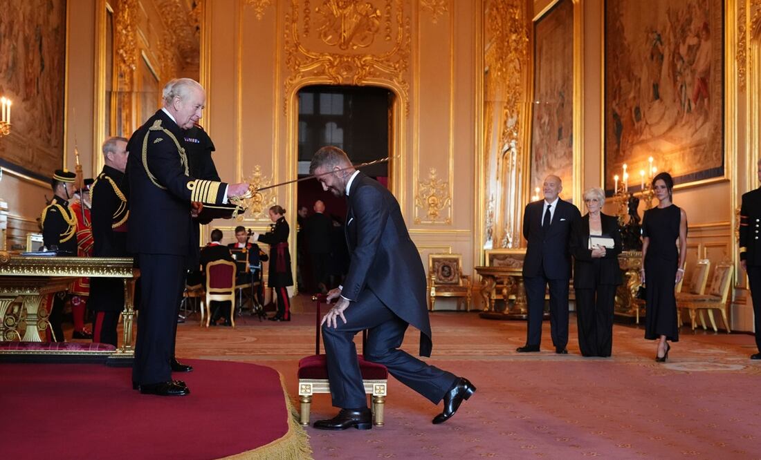 El rey de Inglaterra tocó los hombros del exfutbolista con la hoja de una espada y Beckham se transformó así en Sir David. Foto: AP