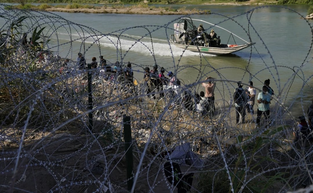 Migrantes que cruzaron a Estados Unidos desde México se encuentran con alambre de púas en la orilla del río Grande, en Eagle Pass, Texas. Foto: AP