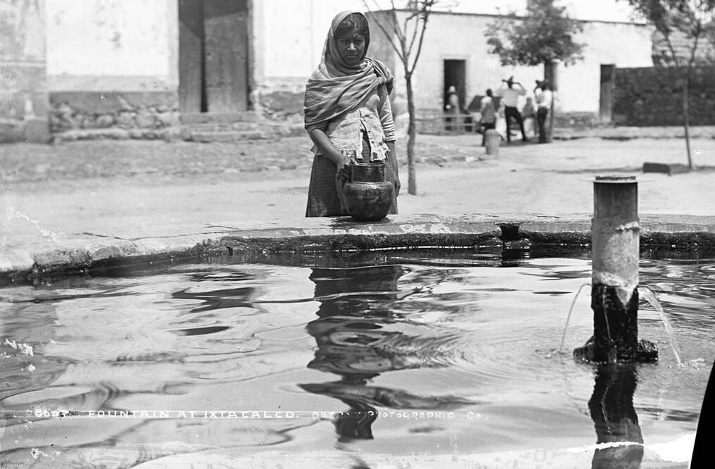 Mujer en Iztacalco abasteciéndose de agua en una fuente de agua potable, año de 1880. Crédito Biblioteca del Congreso de Estados Unidos.