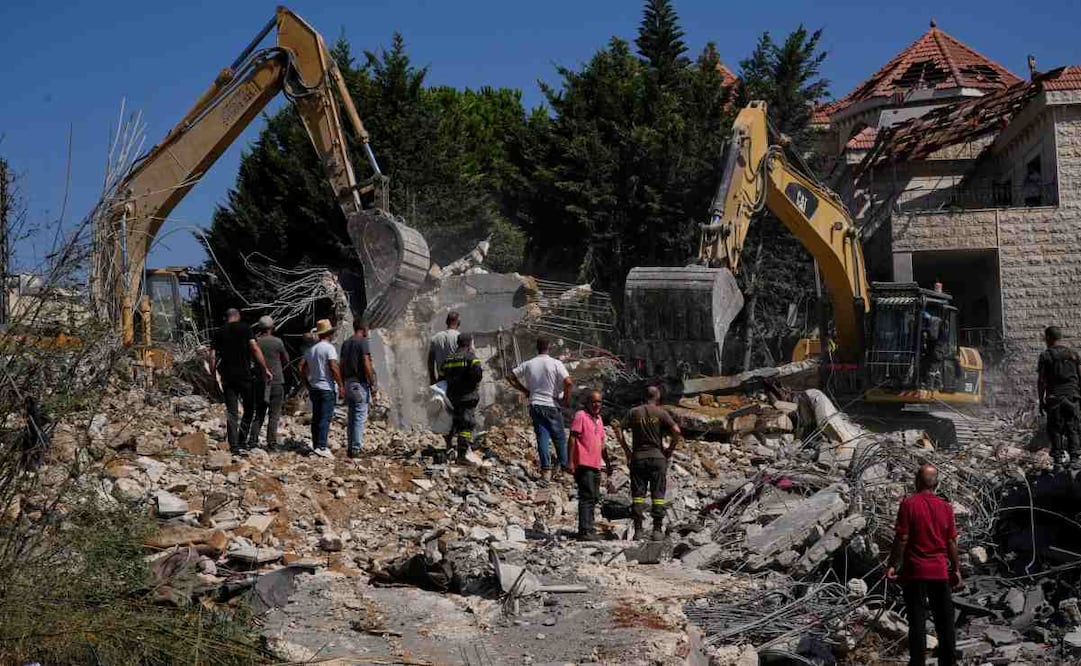 Gente mira a trabajadores de rescate utilizando excavadoras mientras buscan víctimas bajo los escombros de un edificio destruido en un ataque aéreo israelí en el poblado de Kfar Rumman, Líbano, el lunes 7 de septiembre de 2026. Foto: AP