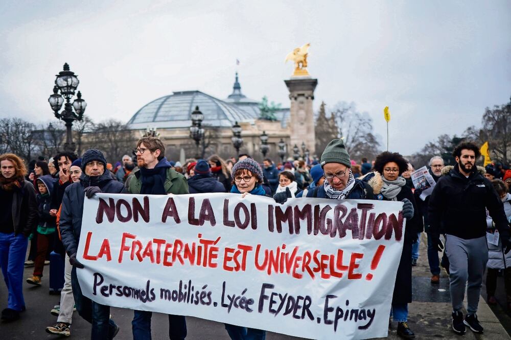 Manifestantes con una pancarta contra la ley de migración, en la protesta organizada por inmigrantes, sindicatos y partidos de izquierda en París. Foto: EFE