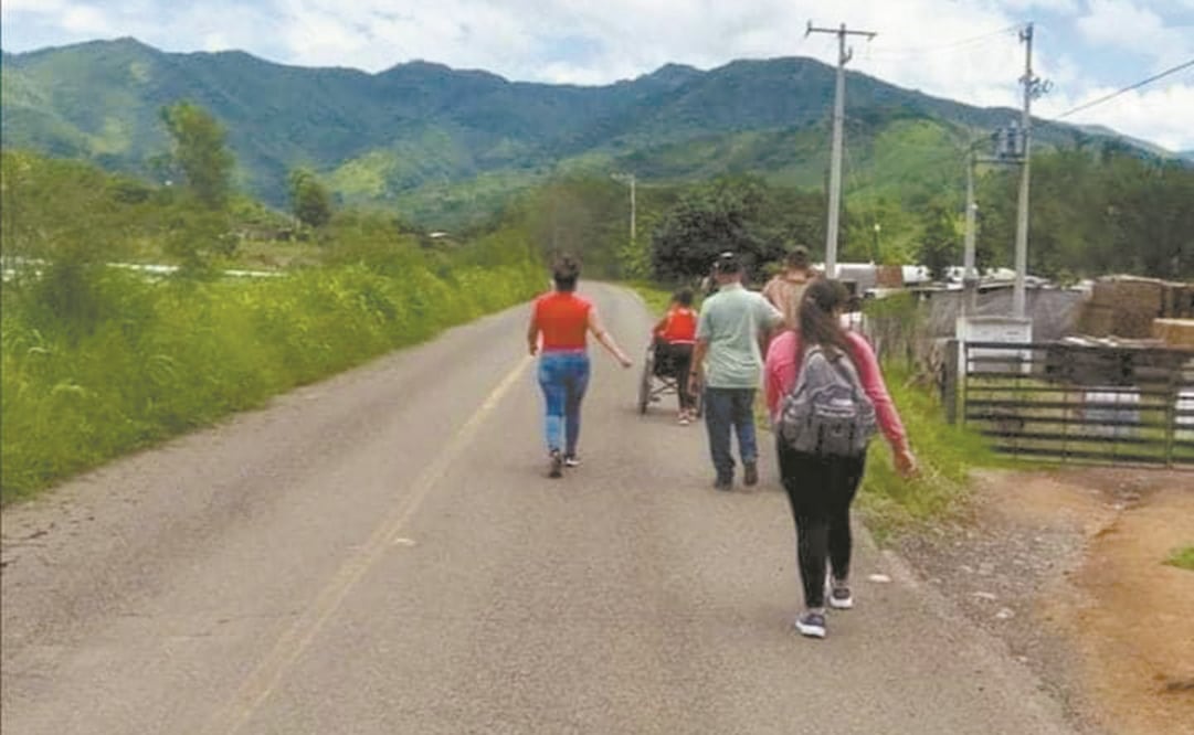A través de redes sociales, se han compartido imágenes de familias enteras dejando sus casas en Coalcomán y caminando por las carreteras con maletas. Foto: Especial.