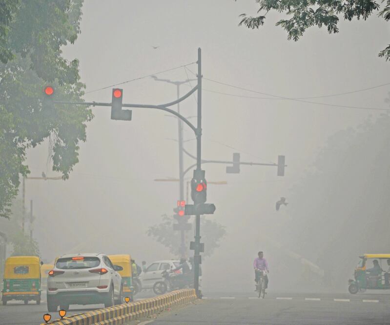 Conductores viajan en una carretera en Nueva Delhi, que ayer amaneció bajo una densa nube de contaminación que obligó a desviar vuelos. Foto/SAJJAD HUSSAIN. AFP