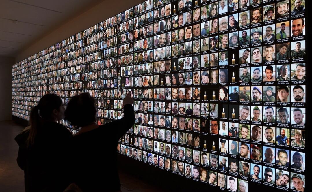 Visitantes observan fotos de israelíes asesinados durante el ataque de milicianos de Hamas el 7 de octubre. Foto: AP