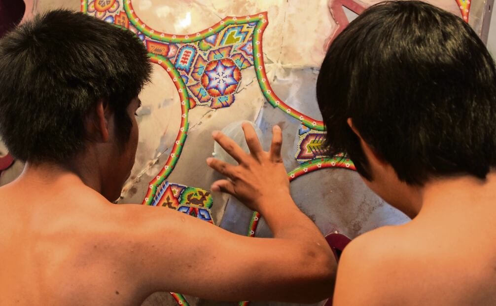 Hombres wixárikas pegan la chaquira sobre la piel de la venada. Foto: Francisco Rodríguez / EL UNIVERSAL