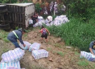 Vuelca tráiler en Oaxaca y gente rapiña paquetes de pañales; pese a presencia de policías, no se frenó el robo de mercancía