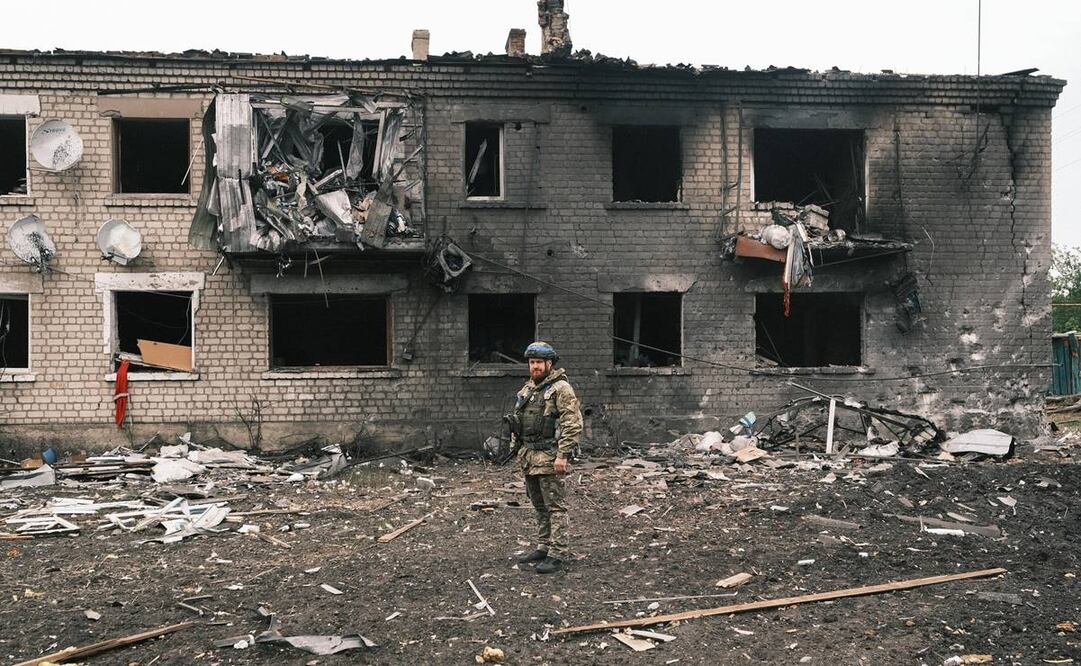 Un oficial de policía ucraniano inspecciona un edificio dañado durante la evacuación de habitantes locales de territorios fronterizos con Rusia. Foto: EFE