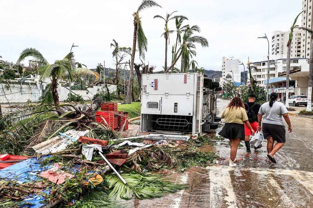 Vecinos caminan entre los escombros en una calle afectada por el huracán Otis, hoy, en el balneario de Acapulco, en el estado de Guerrero (México). El primer reporte de víctimas tras el paso del huracán Otis por la costa sur del estado de Guerrero da cuenta de 27 personas fallecidas y 4 desaparecidas. FOTO: DAVID GUZMÁN. EFE
