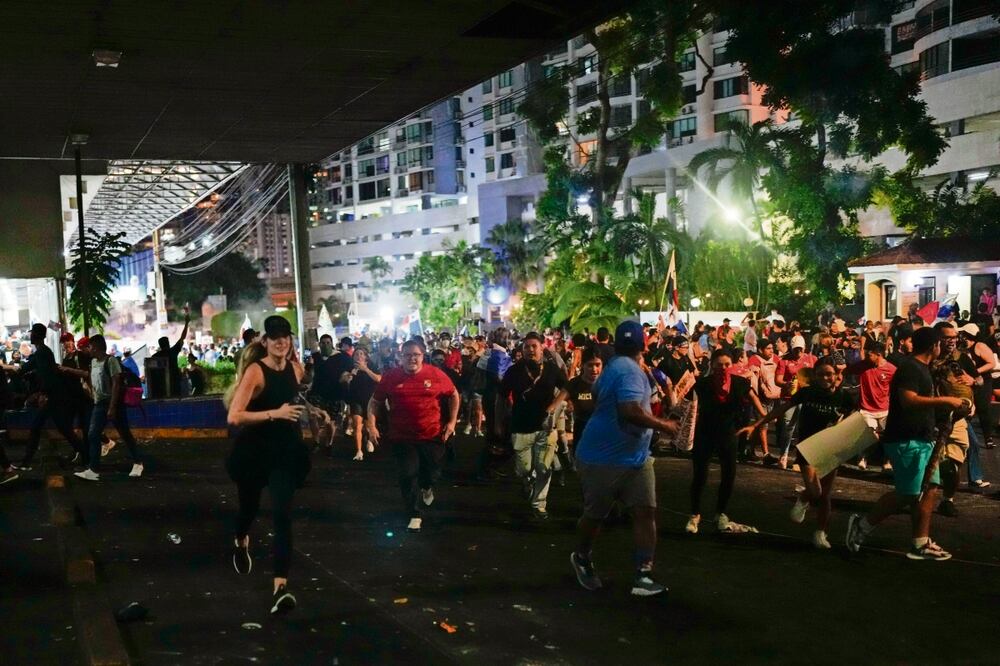 Los manifestantes huyen de los gases lacrimógenos, tras los enfrentamientos contra la policía en una protesta contra un contrato minero recientemente aprobado entre el gobierno y la empresa canadiense First Quantum, en la ciudad de Panamá. Foto: Arnulfo Franco | AP