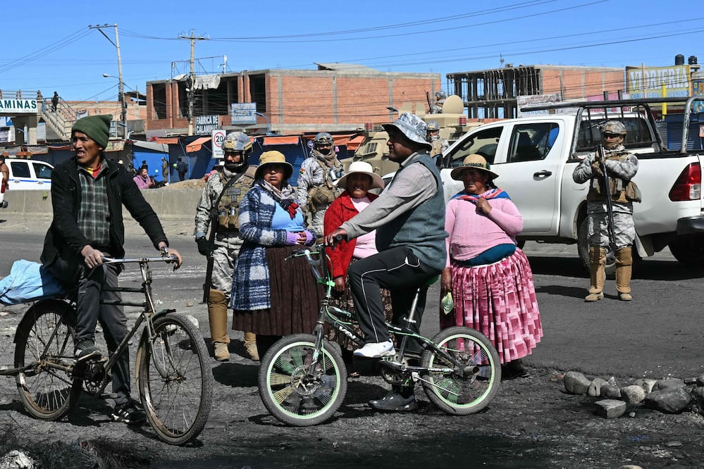 Residentes permanecen cerca de agentes de policía en una zona bloqueada en Cruce Ventilla, El Alto, Bolivia, el 20 de junio de 2026, luego de que el presidente boliviano Rodrigo Paz declarara el estado de emergencia. Foto: AFP