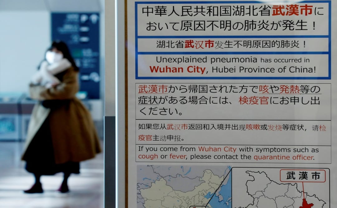 A woman wearing a mask walks past a quarantine notice about the outbreak of coronavirus in Wuhan, China at an arrival hall of Haneda airport in Tokyo, Japan - Photo: Kim Kyung-Hoon/REUTERS