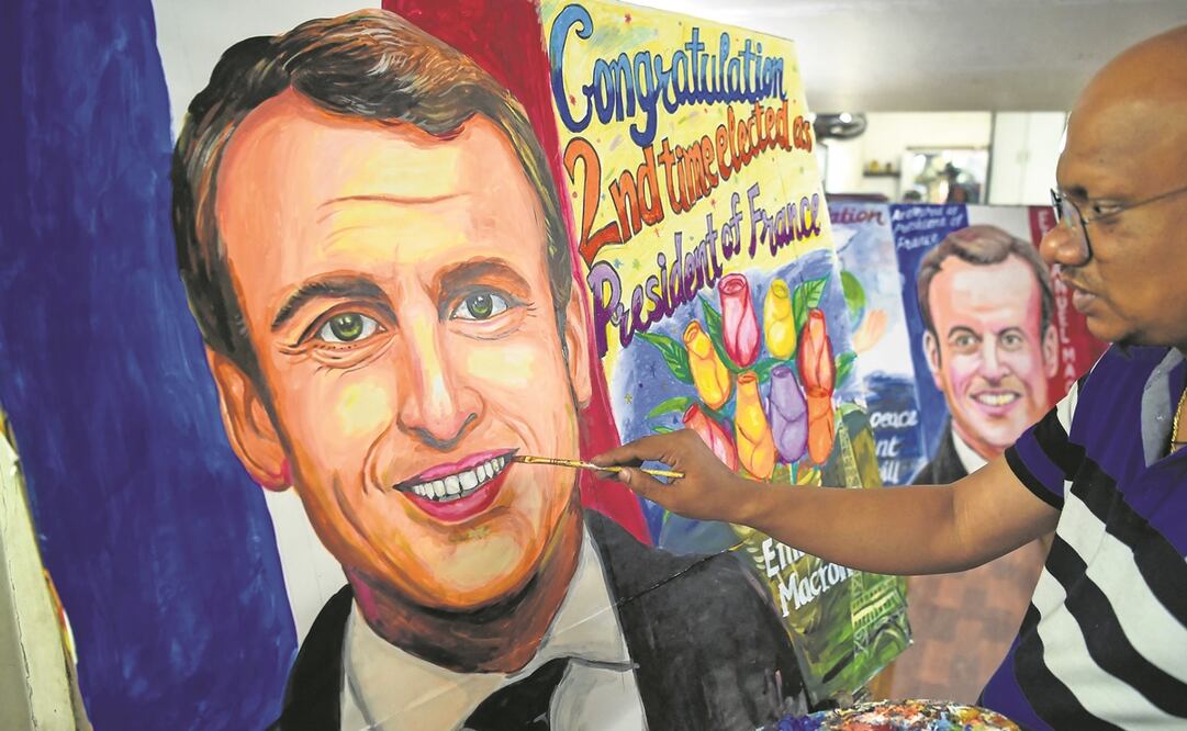 Un artista en India da los últimos toques a una pintura del presidente francés Emmanuel Macron, tras la victoria de éste en los comicios del domingo. Foto: AFP.
