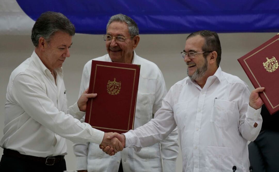 El presidente de Colombia Juan Manuel Santos (izq), de Cuba Raúl Castro (Centro) y el comandante de las Fuerzas Armadas Revolucionarias de Colombia (FARC), Timoleón Jiménez firmaron el acuerdo de cese al fuego y definitivo de los rebeldes colombianos en La Habana. Foto: AP