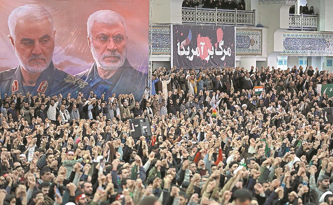Un espectacular muestra al difunto comandante militar iraní Qassem Soleimani y al fallecido líder de la milicia iraquí Abu Mahdi al-Muhandis, mientras los fieles iraníes cantan consignas durante el sermón de las oraciones del viernes. Foto: REUTERS