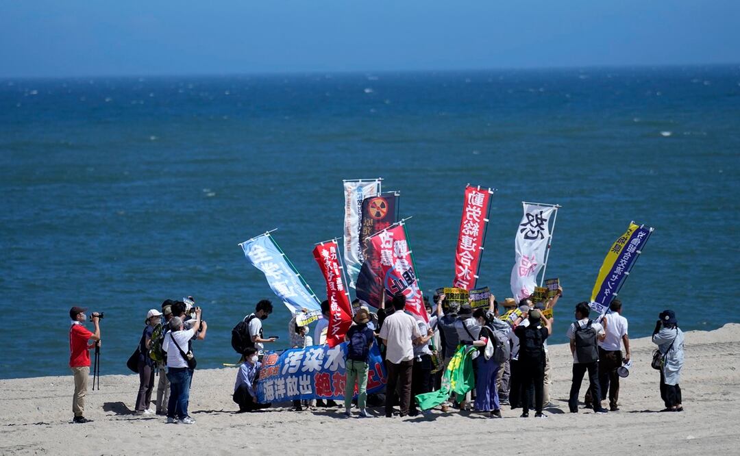 La gente protesta en una playa hacia la planta de energía nuclear de Fukushima Daiichi, dañada por un enorme terremoto y tsunami. Foto: AP