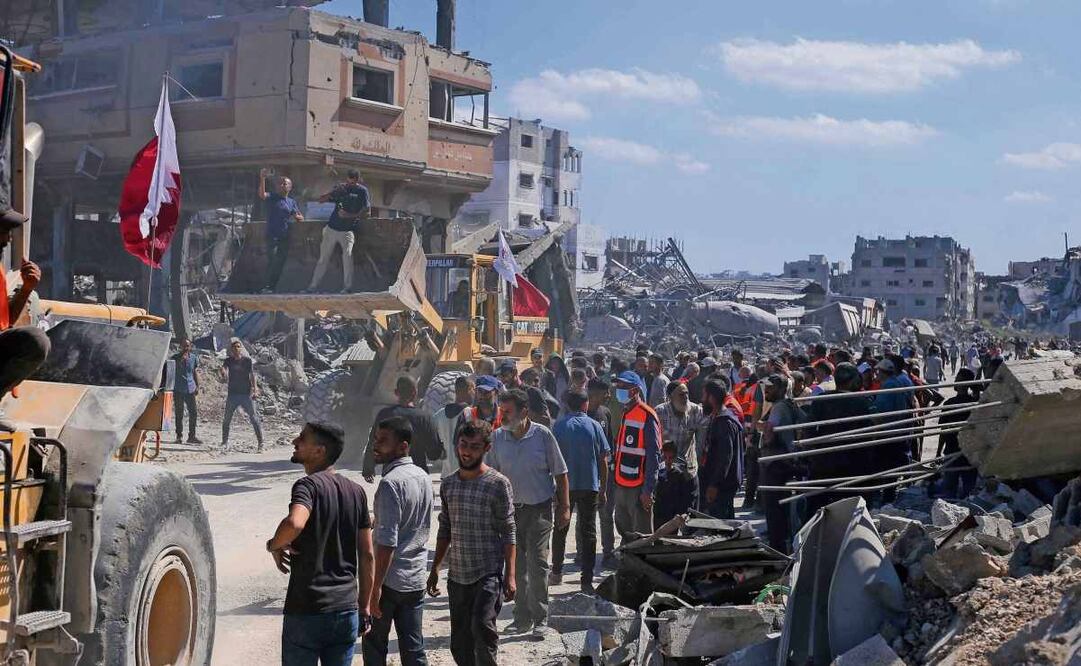 Palestinos, ayer al observar las excavadoras de la municipalidad de Gaza, mientras retiran escombros de los ejes principales y calles de la ciudad. Foto: AFP