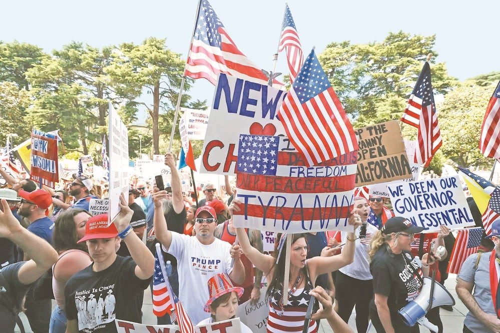 Miembros de ReOpen California protestaron ayer afuera del Capitolio estatal para exigir el fin de la cuarentena en Estados Unidos. Foto: JOHN G. MABANGLO. EFE