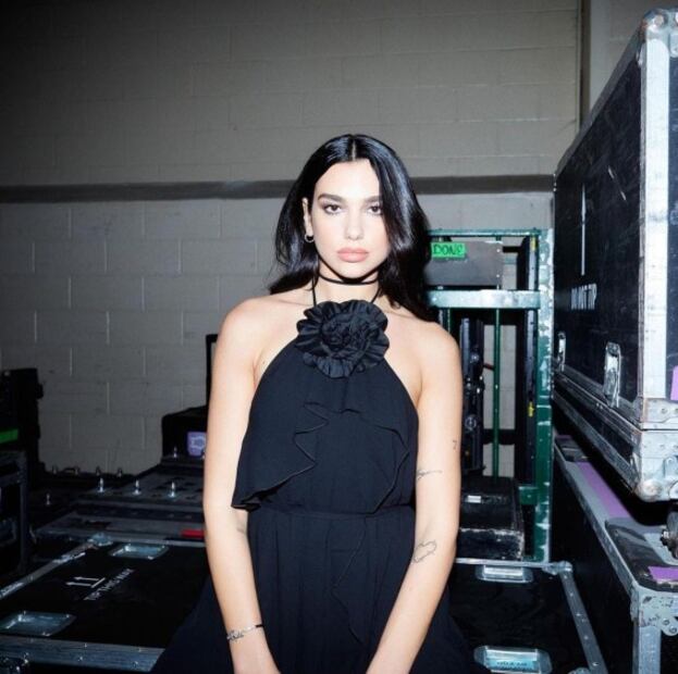 Dua Lipa luce increíble con minivestido negro y botas altas de charol