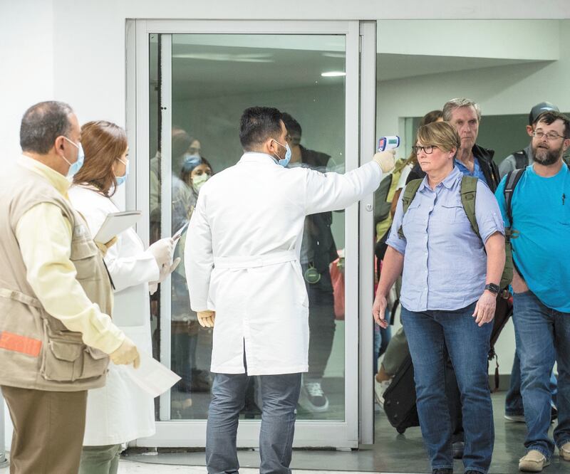 Elementos de la Unidad de Sanidad Internacional del aeropuerto capitalino utilizan un termómetro infrarrojo para medir la temperatura de los pasajeros de vuelos desde el exterior. Foto: GERMÁN ESPINOSA. EL UNIVERSAL