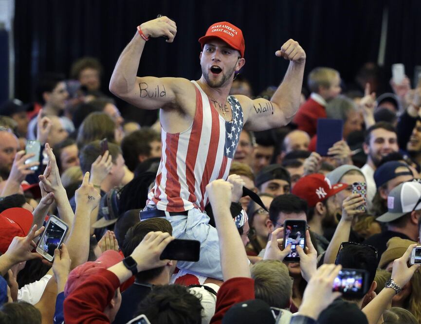 In this April 15, 2016, file photo, a Donald Trump supporter flexes his muscles with the words "Build The Wall" written on them as Trump speaks at a campaign rally in Plattsburgh, N.Y. (AP Photo/Elise Amendola, File)